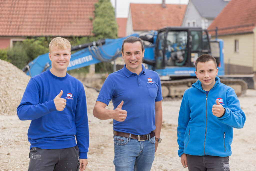 Xaver Neureiter Junior mit zwei Auszubildenden auf der Baustelle der Neureiter GmbH – Zukunft und Ausbildung im Bauhandwerk.
